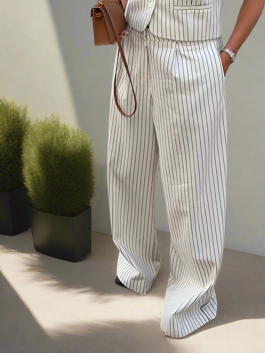 Person wearing a white outfit with vertical stripes on a backyard garden, sunny