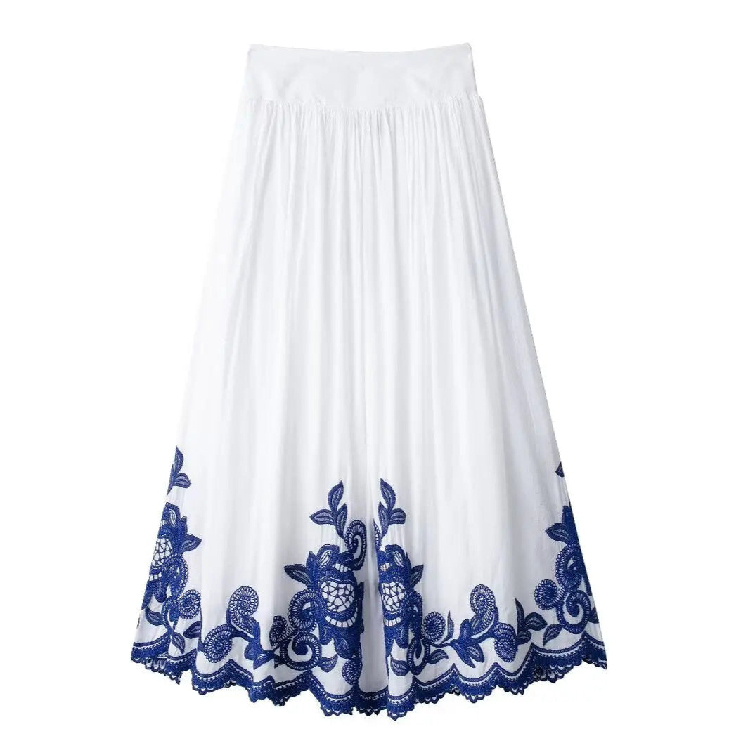 White skirt with blue floral embroidery on a white background