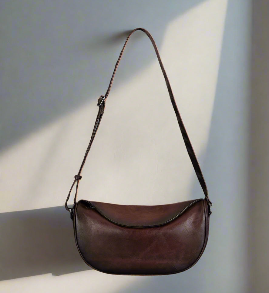 Brown leather shoulder bag on a light background