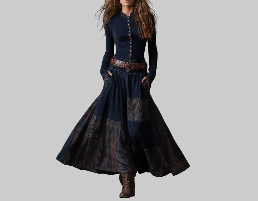 Person wearing a long, dark blue dress with plaid patterns against a gray background