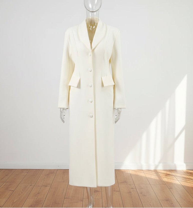 White coat on a mannequin against a white wall with natural light.