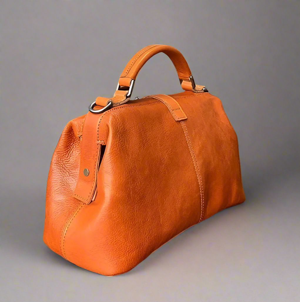 Orange leather bag on a light background.