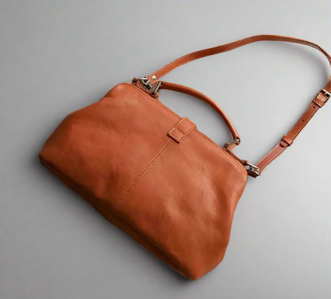 Brown leather handbag on a light background