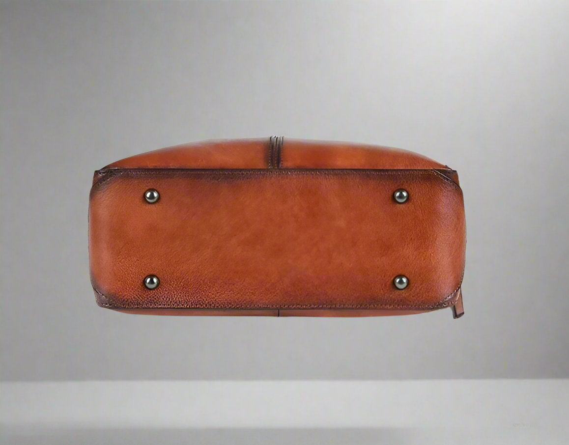 Brown leather bag with silver studs on a white background