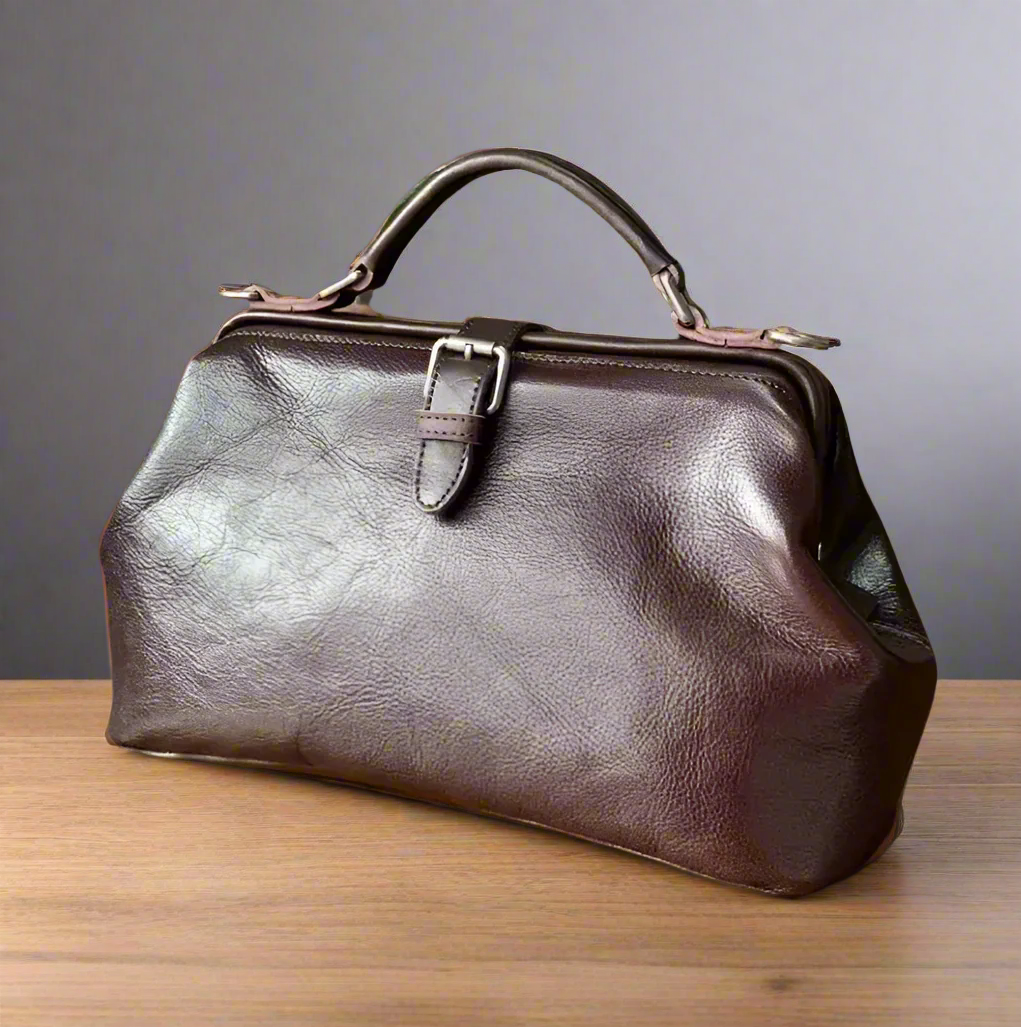 Brown leather handbag on a wooden surface with a gray background
