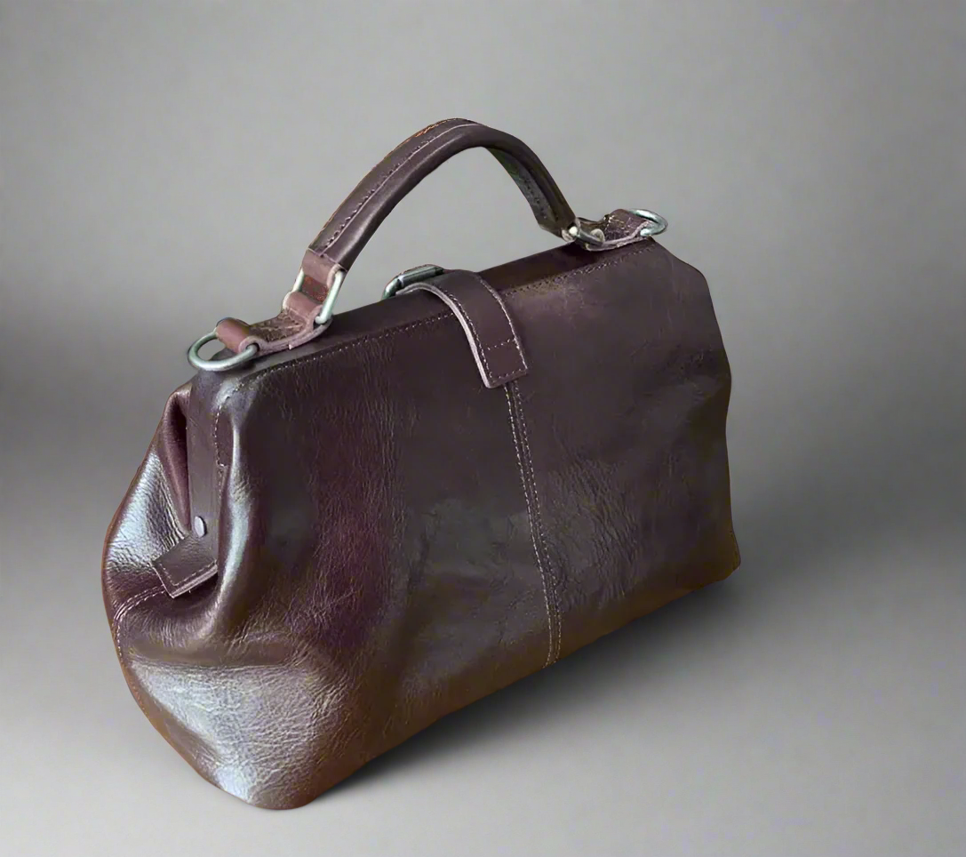 Brown leather bag on a wooden table with a light background