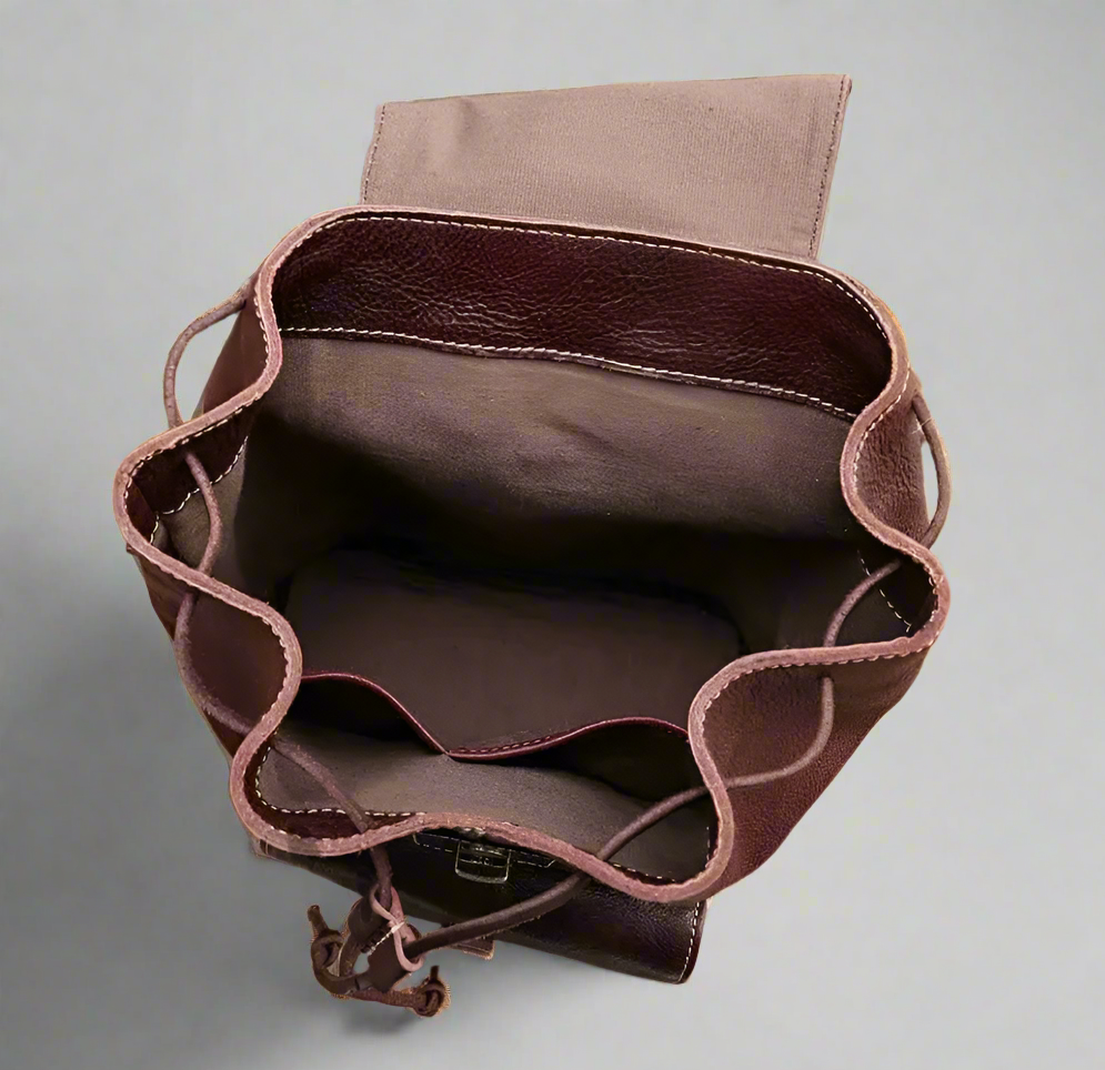Brown leather bag with drawstring on a white surface