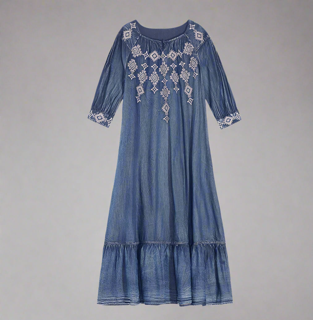 Blue denim dress with intricate white embroidery on a white background