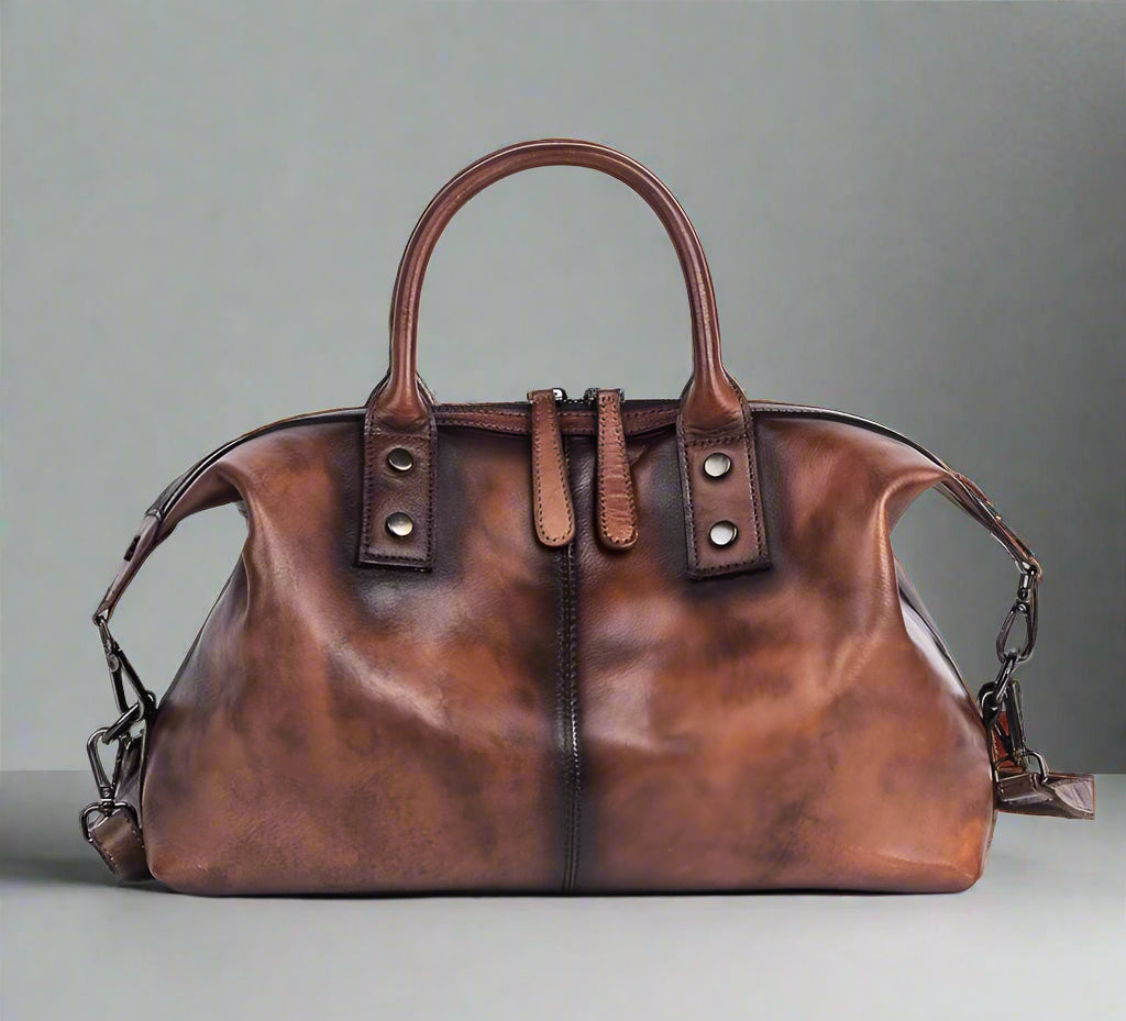 Brown leather handbag with chain detail on a white background
