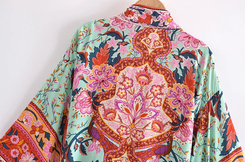 Colorful floral and paisley patterned shirt on a mannequin against a white background