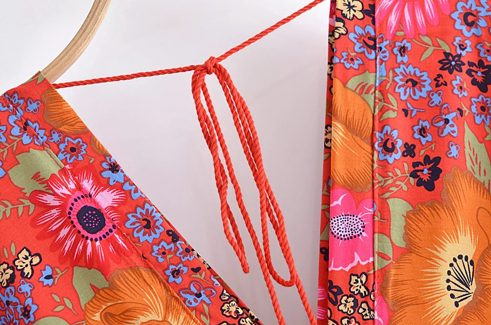 Colorful floral-patterned fabric with a wooden hoop and red string on a white background