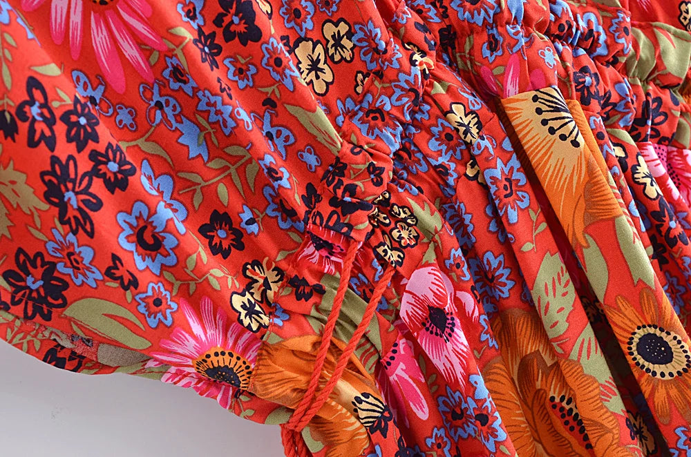 Close-up of colorful floral fabric with vibrant red, orange, and blue patterns.
