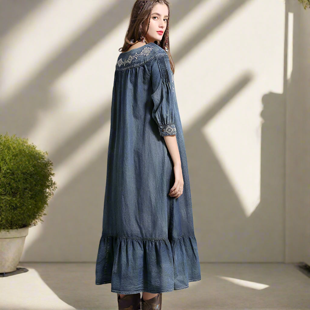 Woman wearing a blue denim dress with lace details against a backyard garden