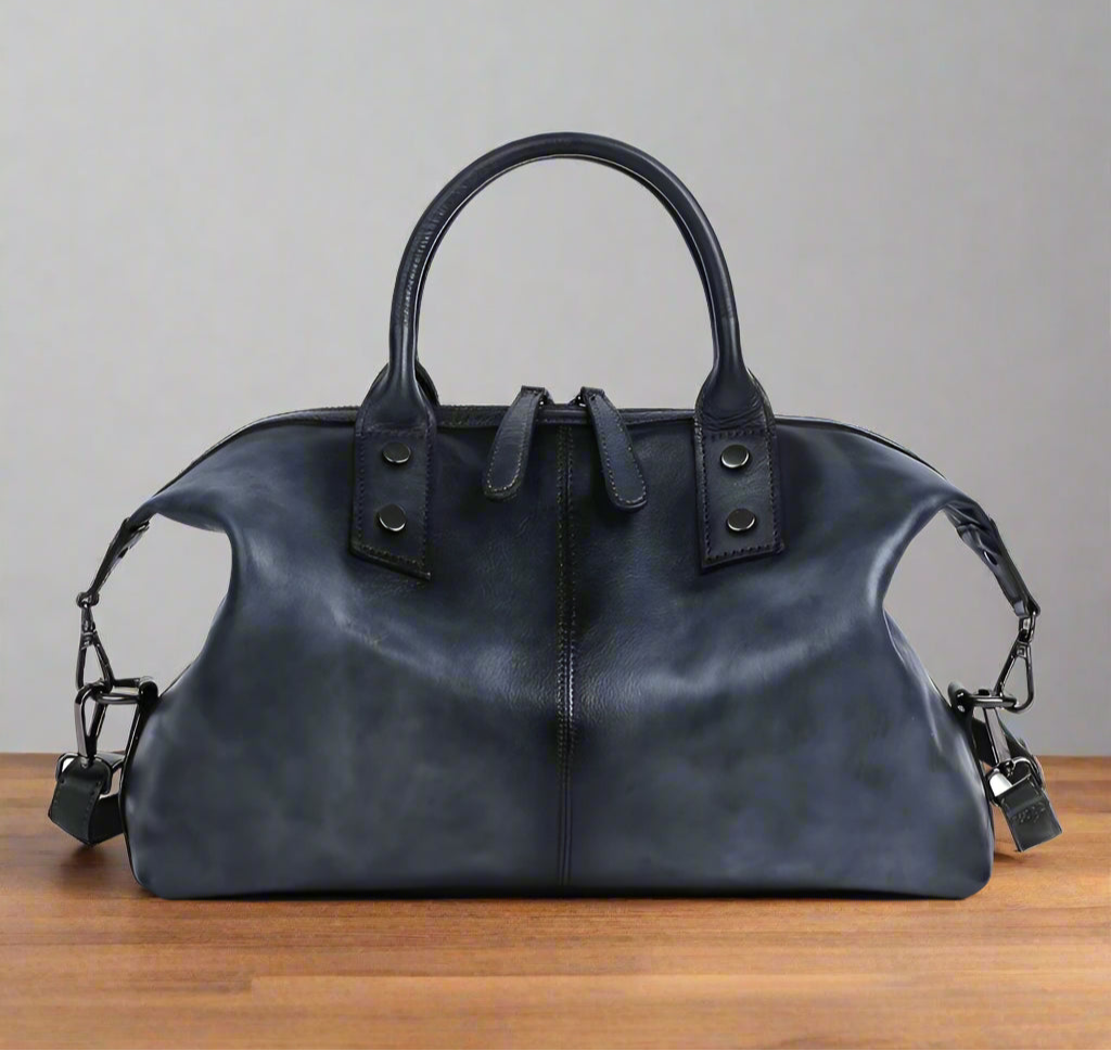 Black leather handbag with shoulder straps on a white background