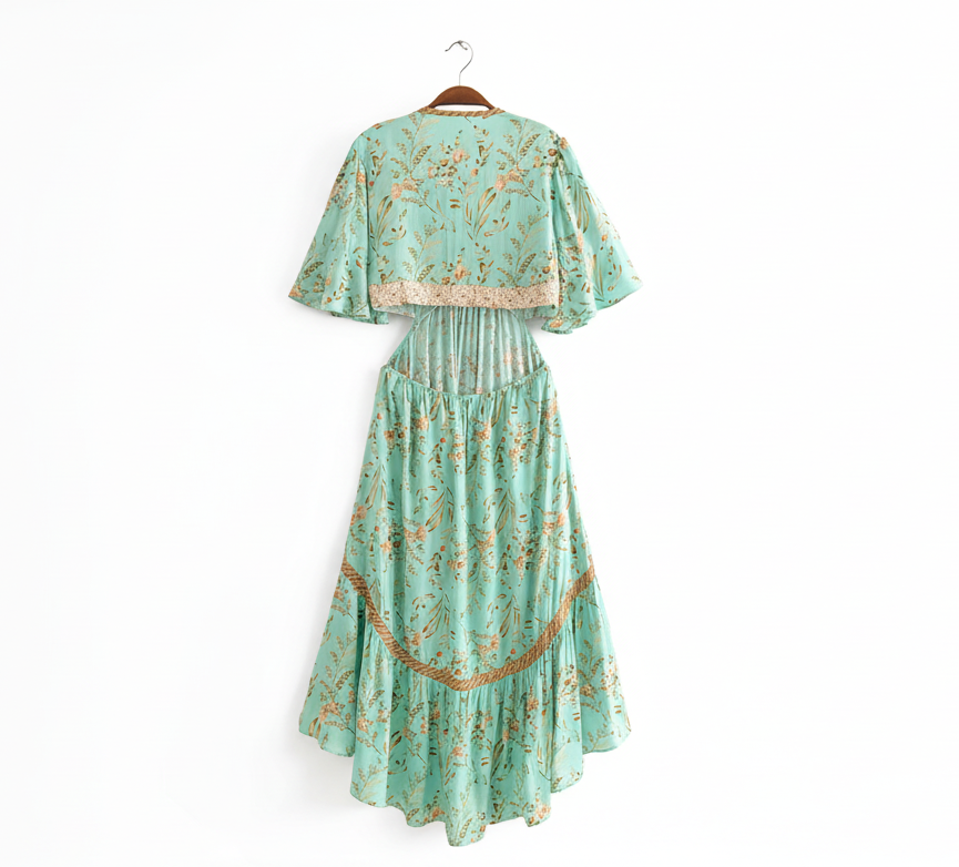 Green floral dress on a hanger against a white background