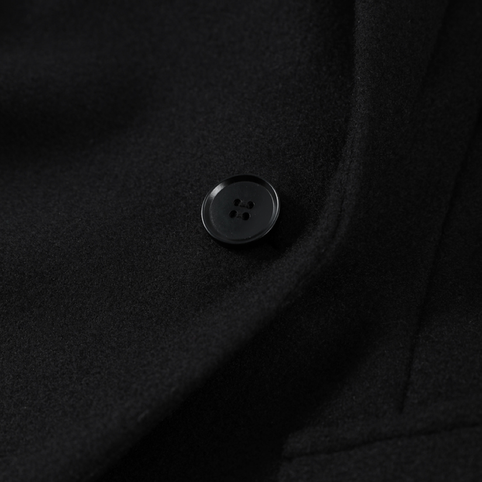 Close-up of a black button on dark fabric