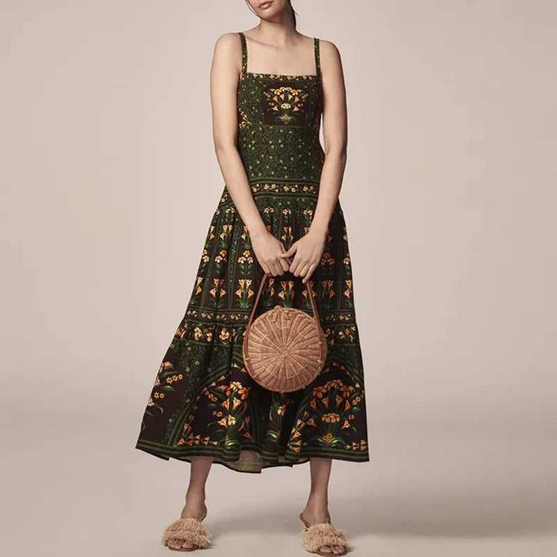Woman wearing a dark green floral dress holding a woven bag against a beige background