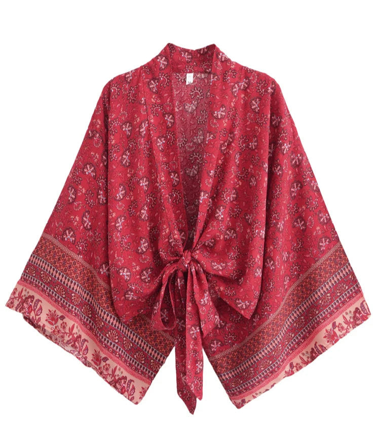 Red patterned scarf with a tie on a white background