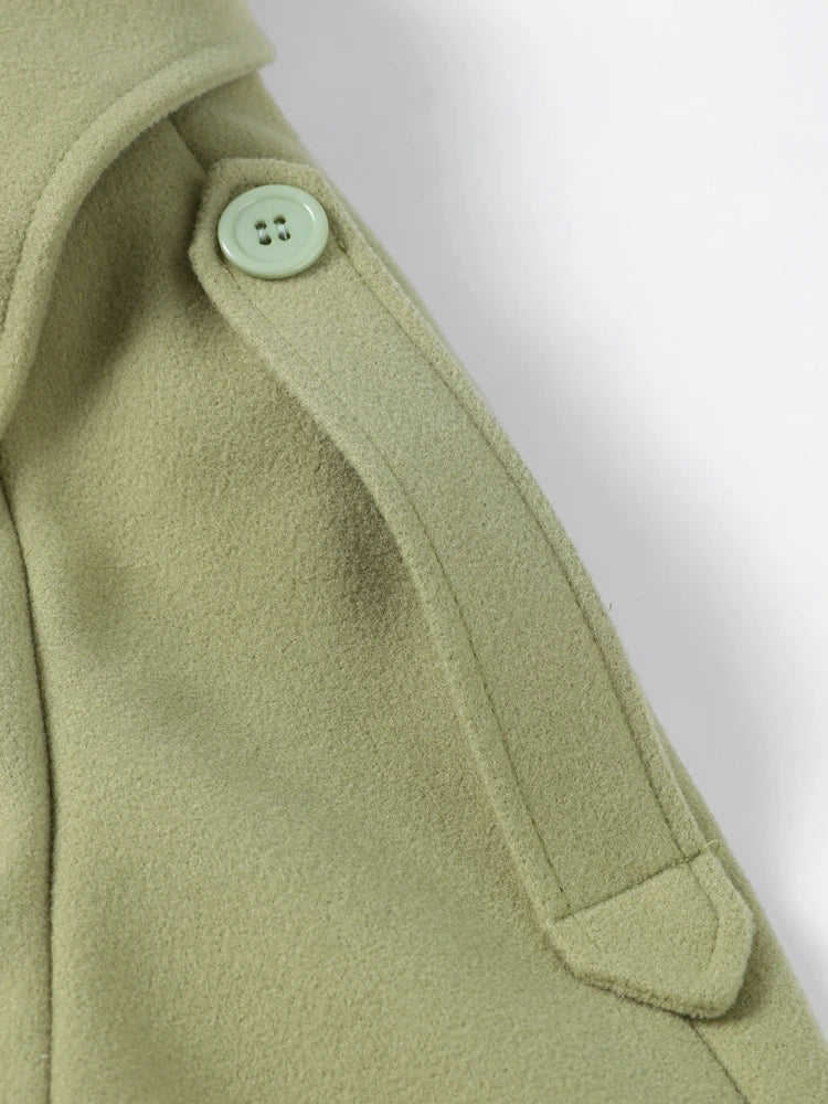 Close-up of a green coat with a button on a white background