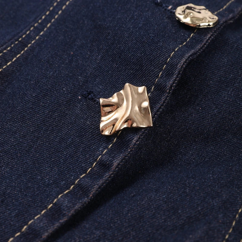 Close-up of a gold button on a dark blue denim fabric