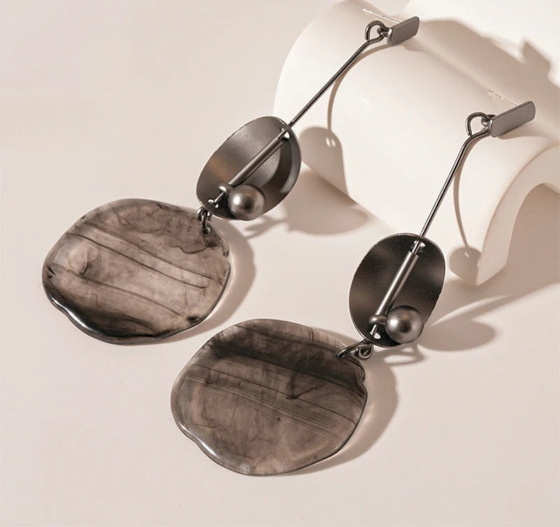 Pair of silver earrings with a neutral background