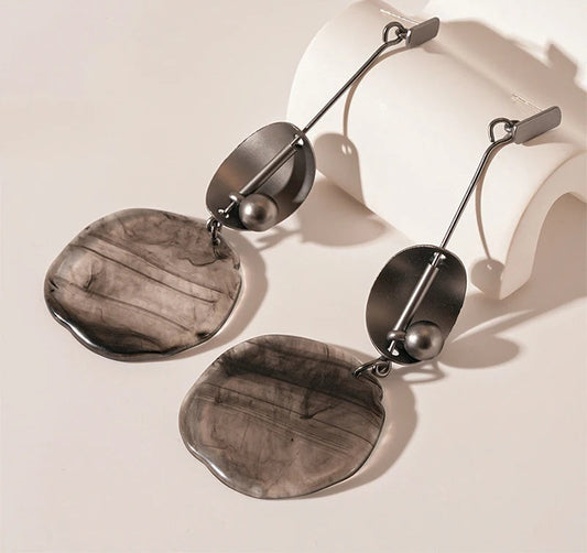 Pair of silver earrings with a neutral background