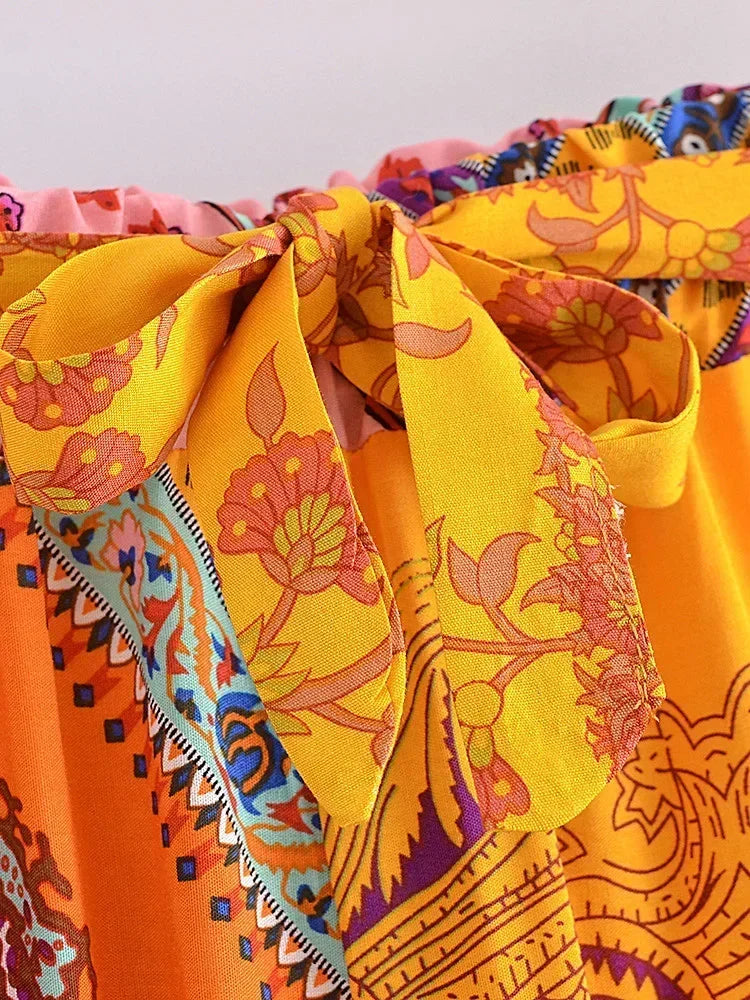 Close-up of a colorful fabric with intricate patterns in orange, yellow, and blue.