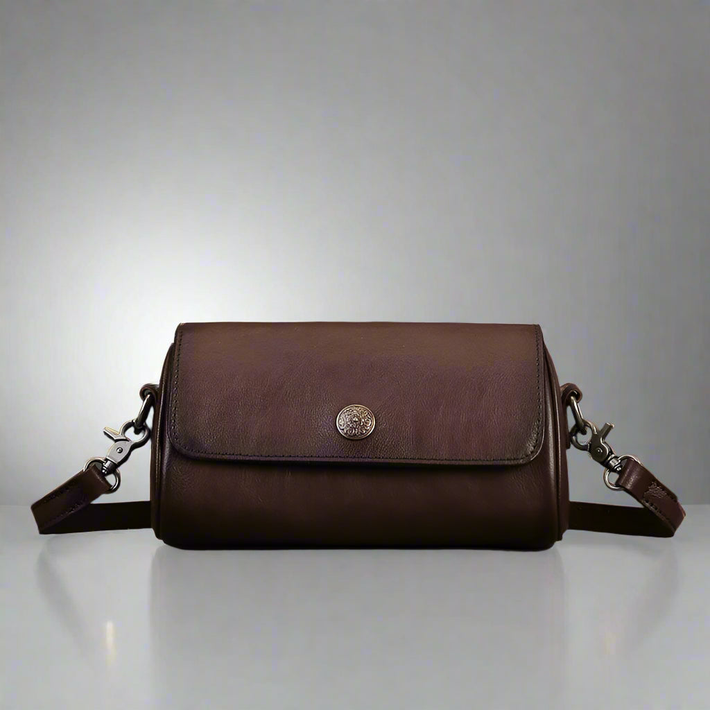 Brown leather bag with a metal clasp on a gray surface 