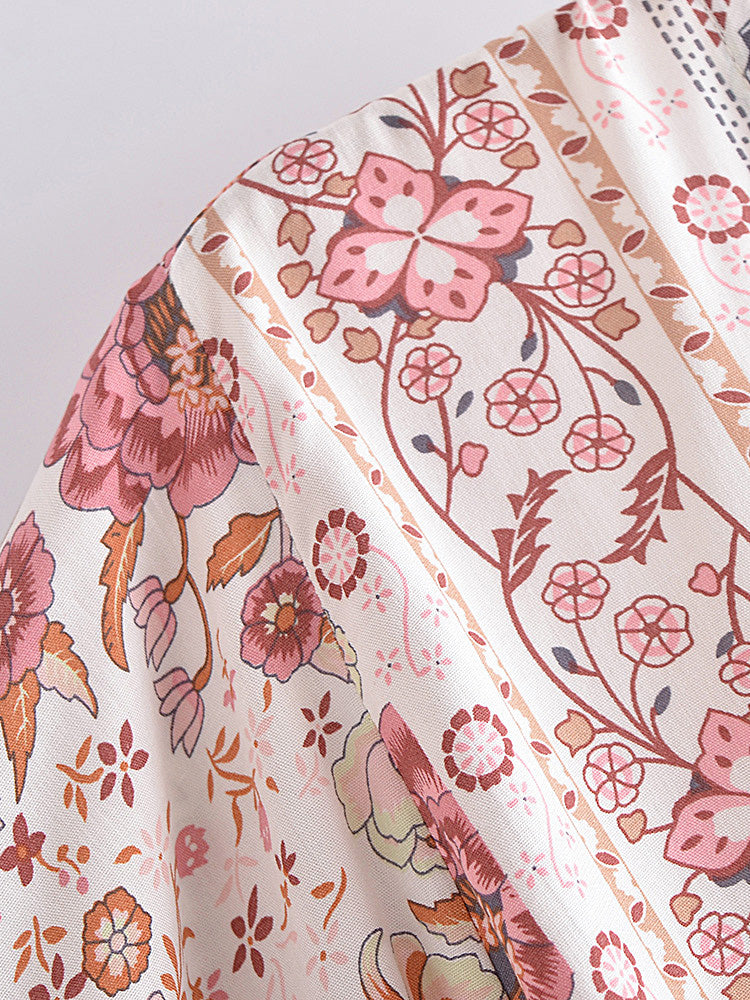 Close-up of floral-patterned fabric with pink and orange flowers on a white background