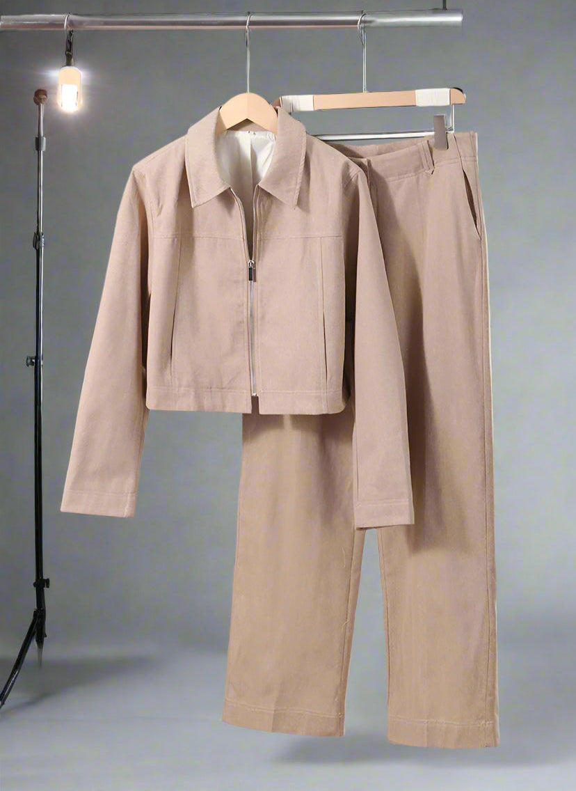 Beige jacket and pants set on a rack with a minimal background