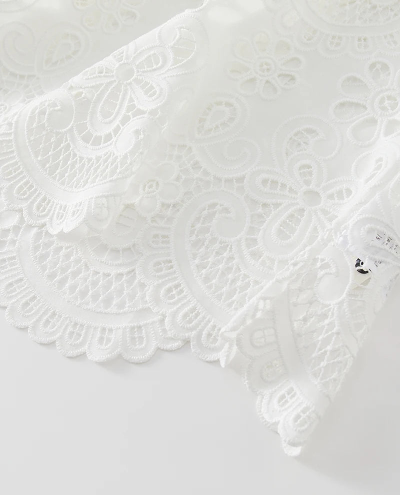 Close-up of white lace fabric on a light gray background