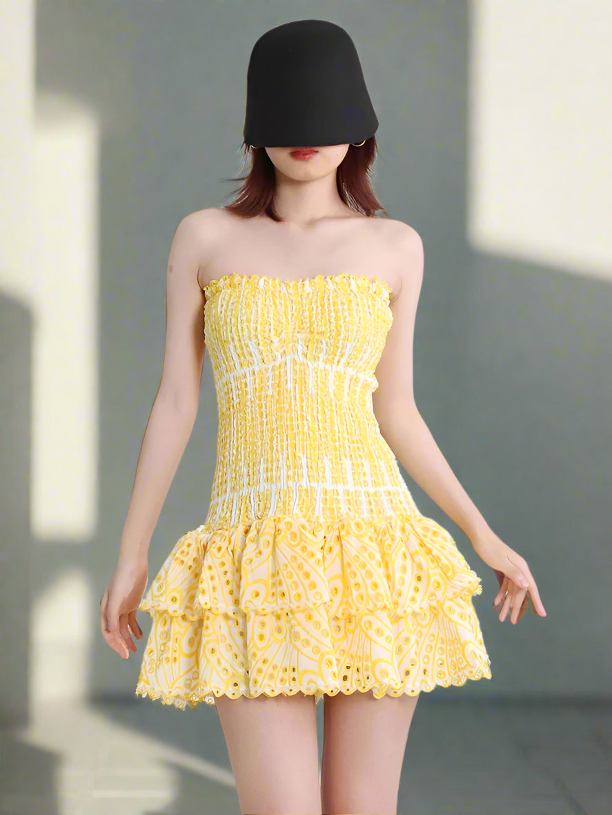 Woman wearing a yellow strapless dress on a white background