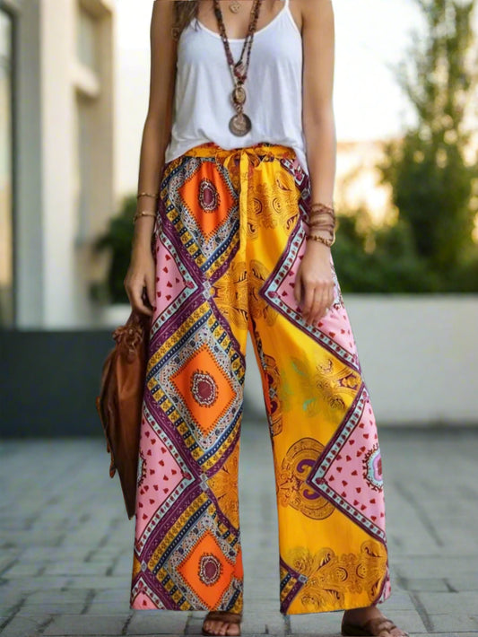 Person wearing colorful patterned pants with a white top outdoors.