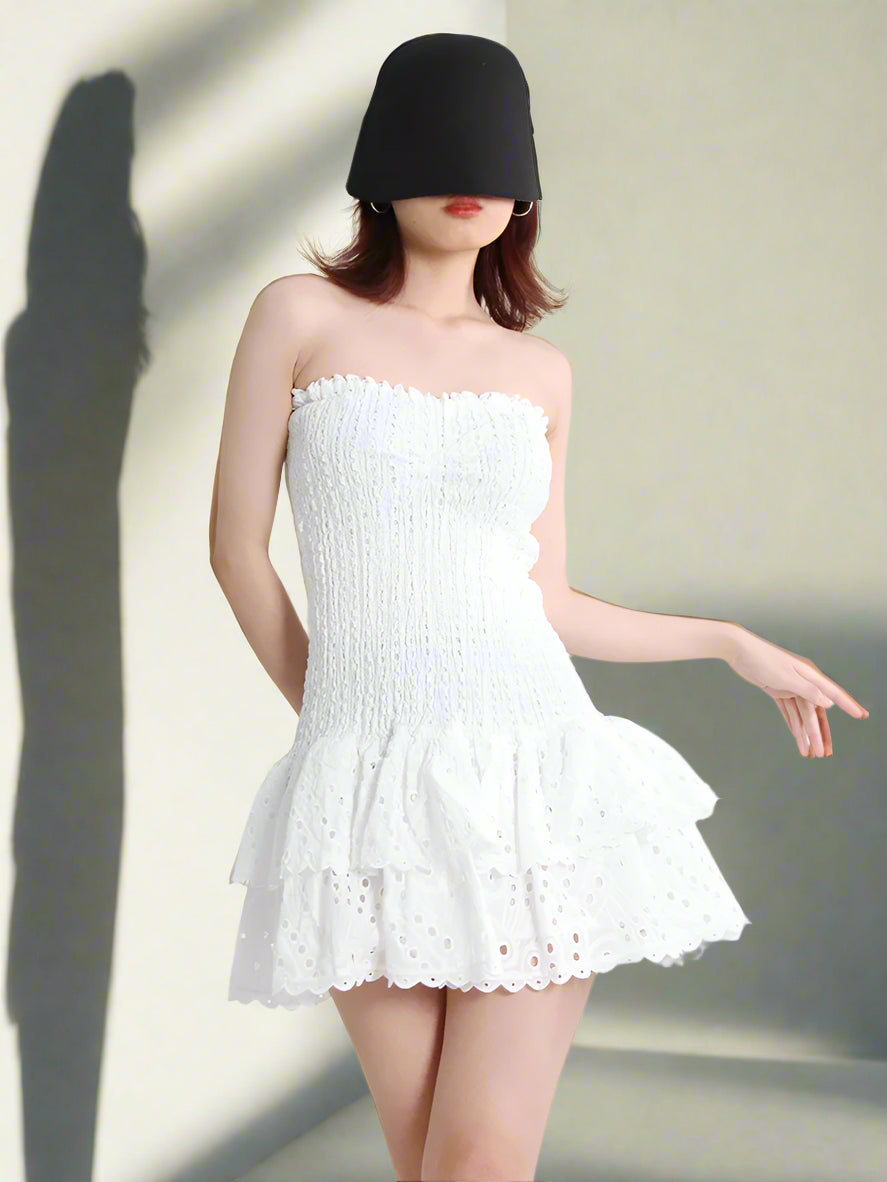 Woman wearing a white strapless dress with a plain background