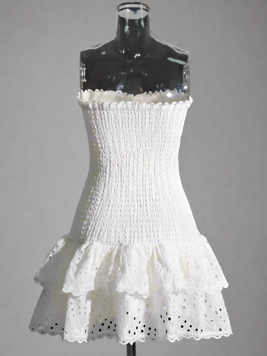 White strapless dress with ruffled hem on a mannequin against a plain background