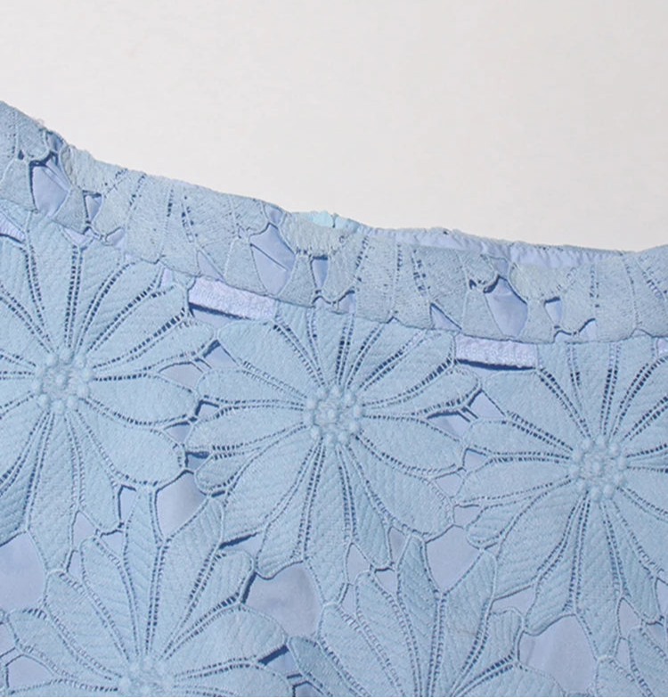 Light blue lace fabric with floral patterns on a white background