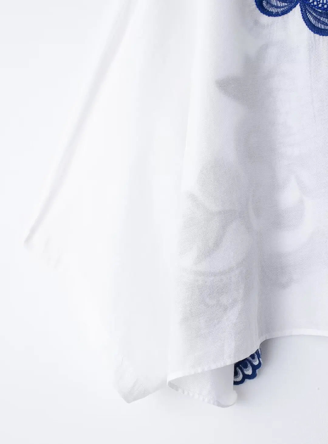 White fabric with blue embroidery on a white background