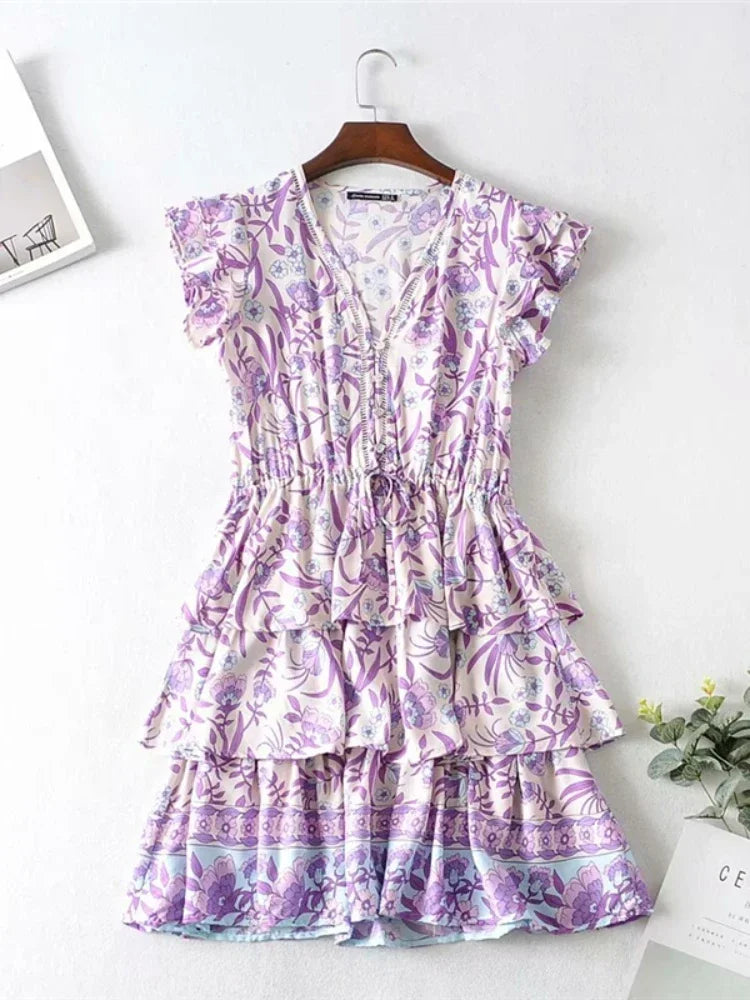 Purple floral dress on a hanger against a white background