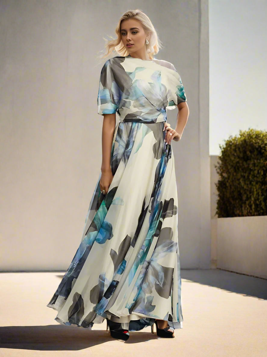 Woman in a long, patterned dress standing outdoors with a cityscape in the background