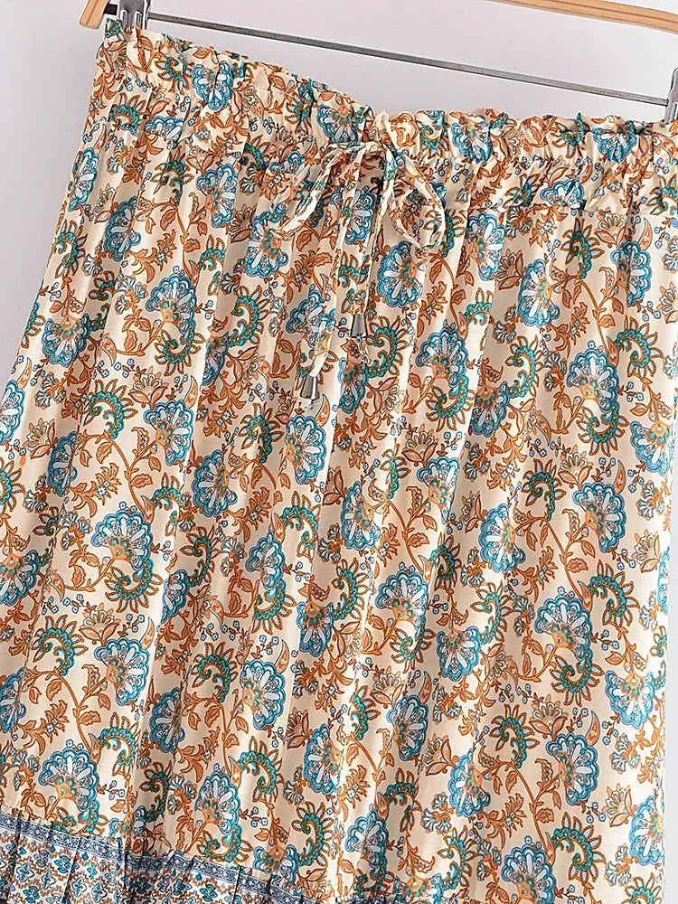 Floral patterned curtain on a rod against a white background