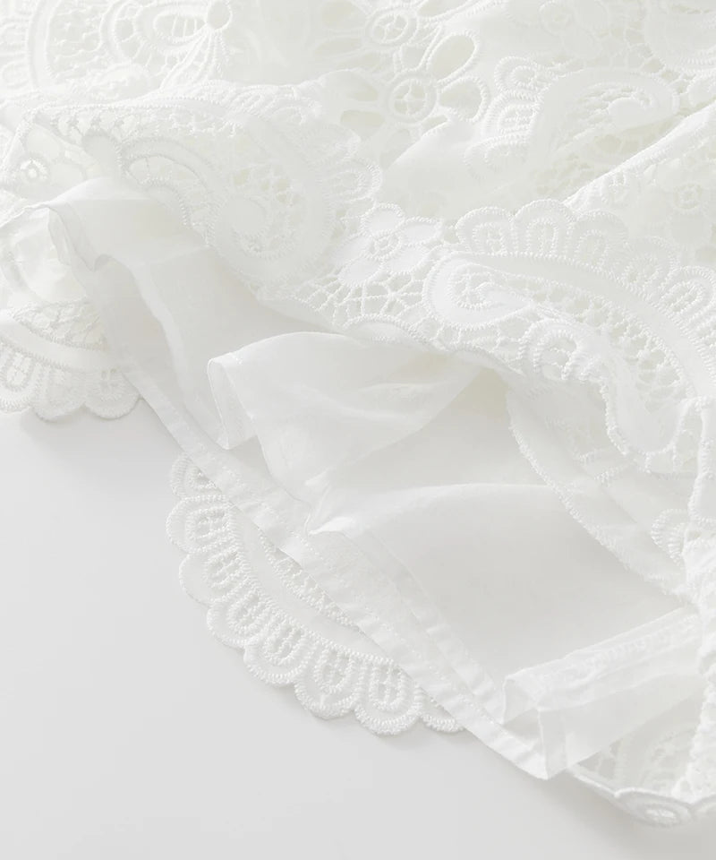 Close-up of white lace fabric on a light gray background