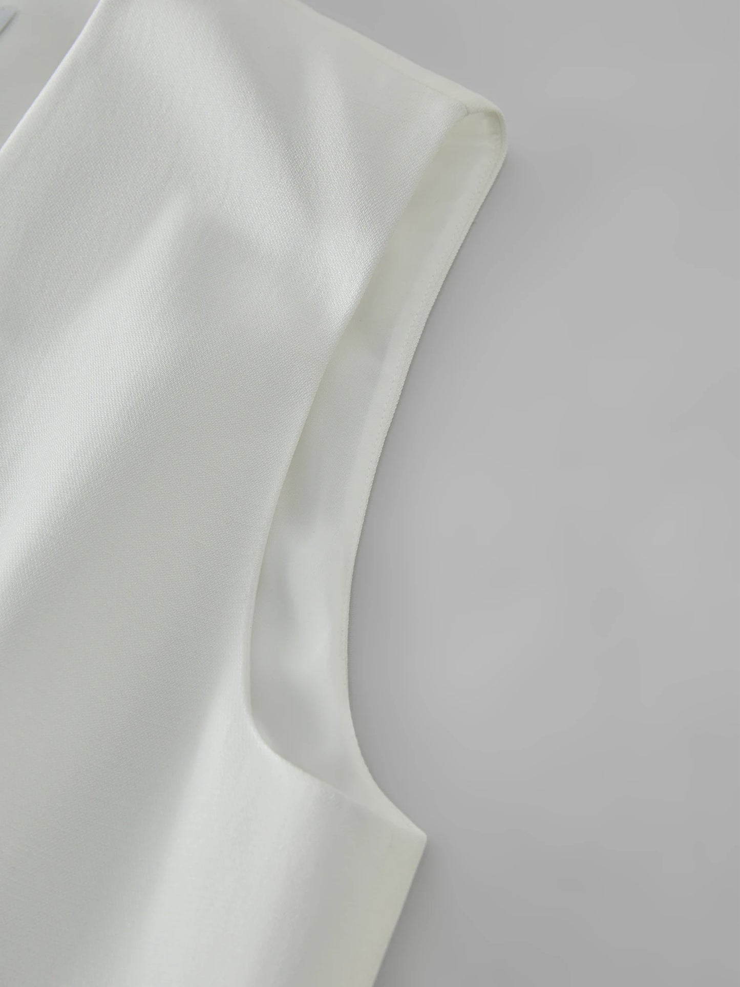 Close-up of a white fabric with a subtle texture on a light gray background