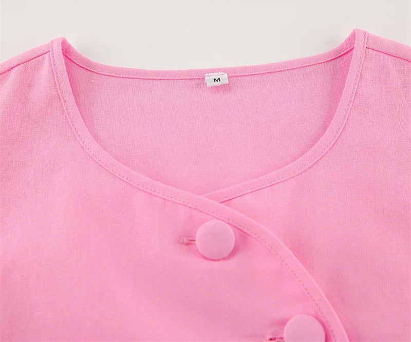 Close-up of a pink garment with buttons on a light gray background