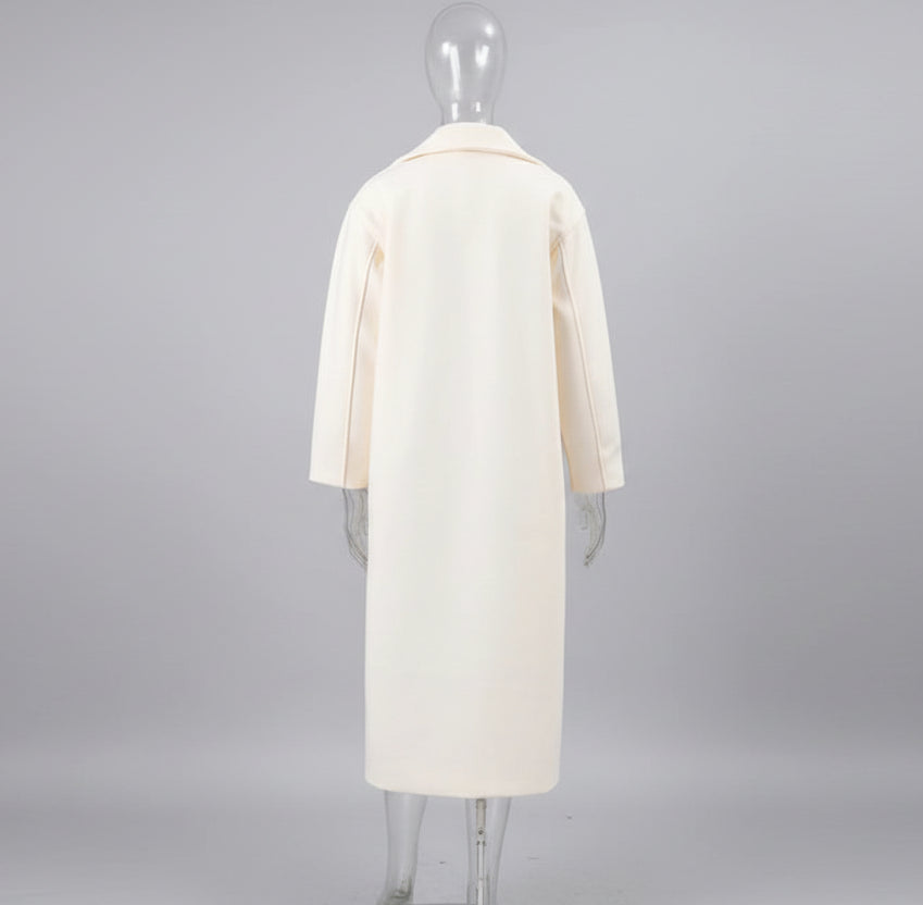 Mannequin wearing a cream-colored dress with a white wall 