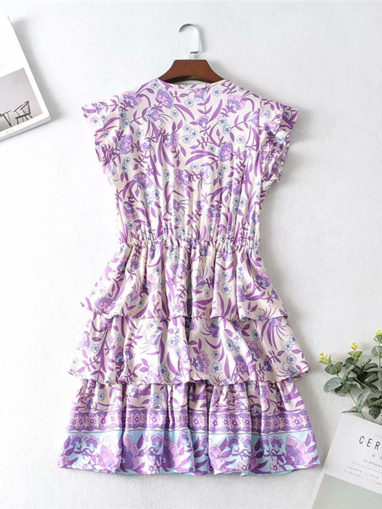 Purple floral dress on a hanger against a white background