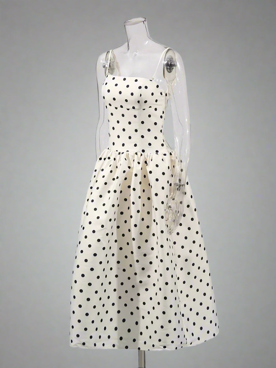 White dress with black polka dots on a mannequin against a white background