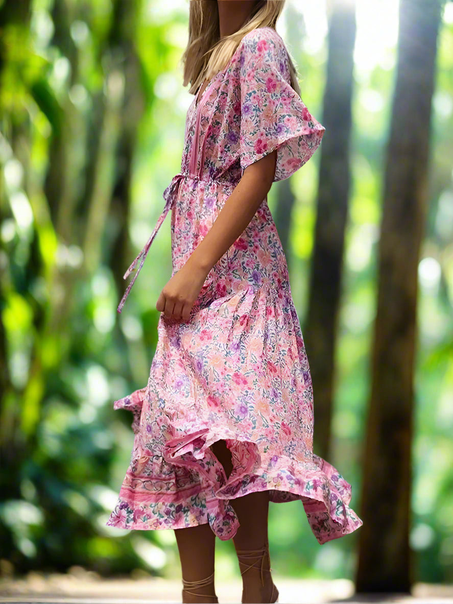 Woman wearing a floral dress with a green garden background