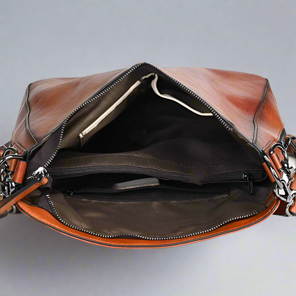 Brown leather bag with chain detail on a white background