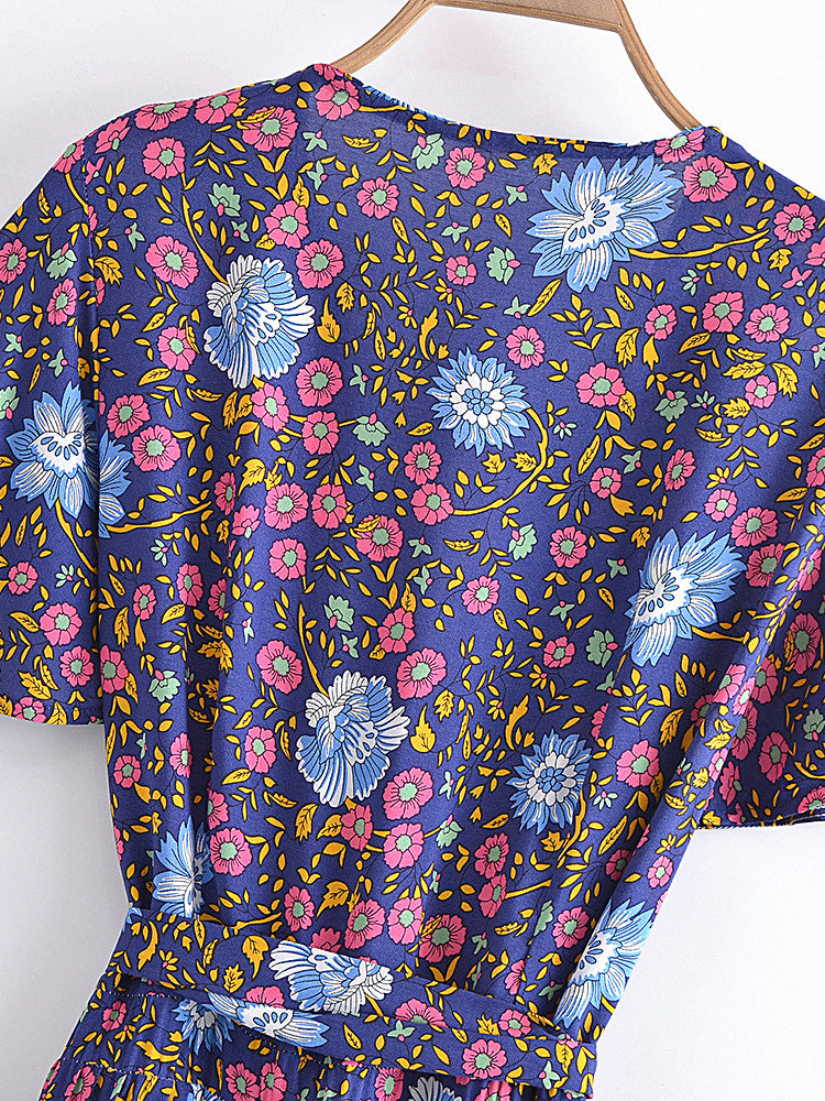 Colorful floral-patterned top on a wooden hanger against a white background