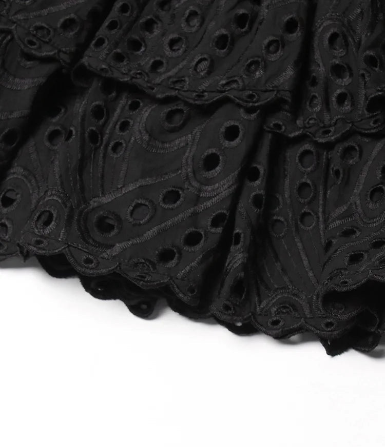 Black lace fabric with intricate patterns on a white background